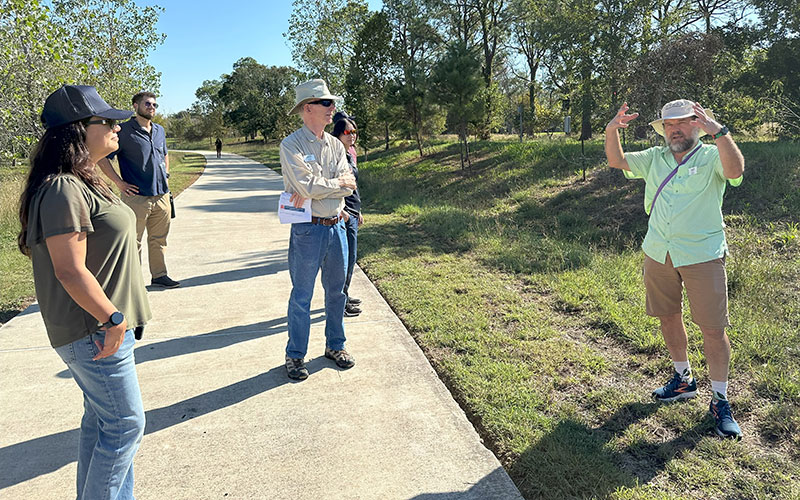 Man talking to a group of people on a wooded path